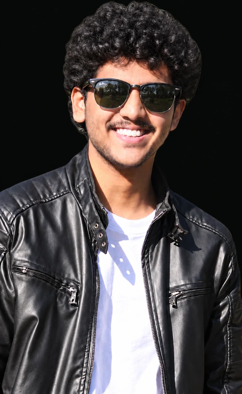Rishwanth smiling, wearing sunglasses and a black leather jacket
